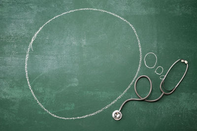 Stethoscope with speech bubble on blackboard