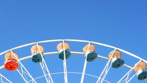 Cropped image of ferris wheel against clear blue sky