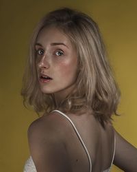 Portrait of girl over yellow background