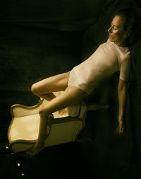 Woman resting her legs on a classic armchair iv