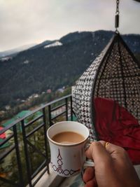 Man holding coffee cup and spoon