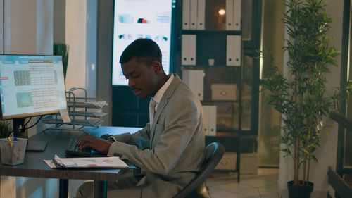 Side view of man working at desk in office