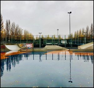 Scenic view of lake against sky in city