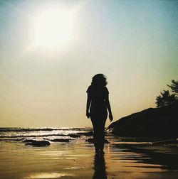 Silhouette of people on beach at sunset