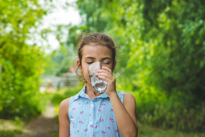 Front view of girl drinking water from glass