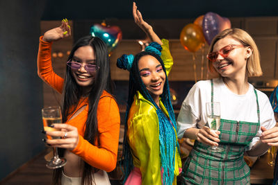 Portrait of smiling friends with hands in party