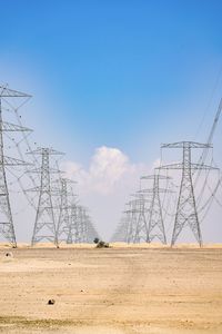 Electricity pylon on field against sky