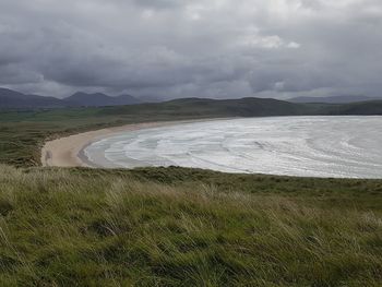 Scenic view of field and mountains against sky