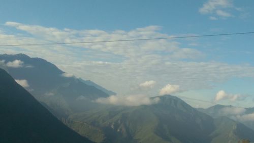 Scenic view of mountains against cloudy sky