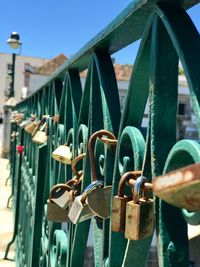 Close-up of padlocks on railing against bridge