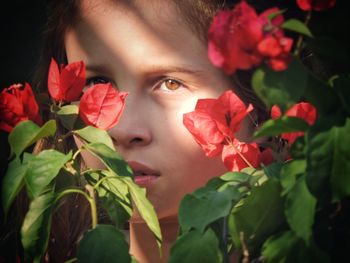 Close-up portrait of girl with red flowers