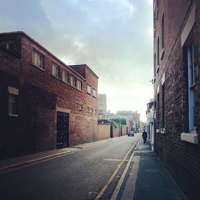 building exterior, architecture, built structure, the way forward, sky, street, transportation, road, diminishing perspective, city, vanishing point, road marking, cloud - sky, cloud, building, car, incidental people, residential structure, residential building, outdoors