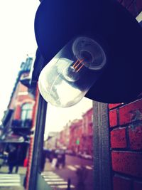 Low angle view of light bulb hanging on wall