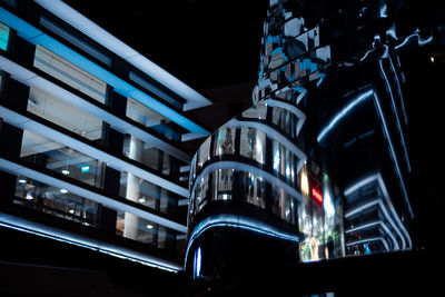 Low angle view of illuminated buildings against sky at night