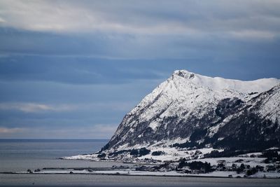 Scenic view of snowcapped mountains by sea against sky