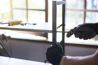 Close-up of hand holding objects on table