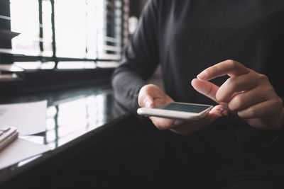 Midsection of man using mobile phone