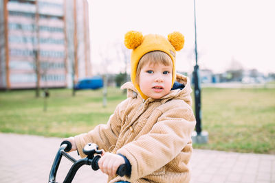 A small child learns to ride a bike for the first time in the city in spring