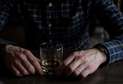 Midsection of man holding beer glass