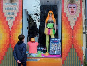 Rear view of man standing against multi colored wall