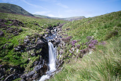 Scenic view of waterfall against sky