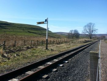 Railroad tracks against clear blue sky