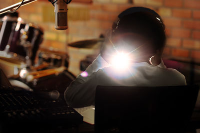 Light beam streaming through man sitting in recording studio