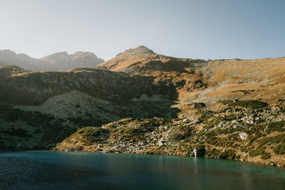 Scenic view of lake and mountains against clear sky