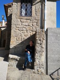 Full length of boy sitting on staircase of building