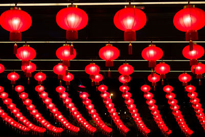 Low angle view of illuminated lanterns hanging at night