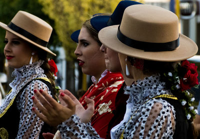 Close-up of women in traditional clothing clapping while standing outdoors