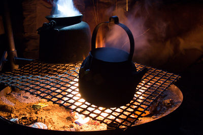 Close-up of teapots on fire