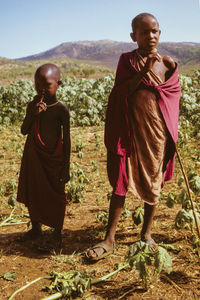 Full length of friends standing on field