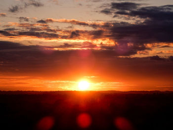 Silhouette of landscape against cloudy sky during sunset