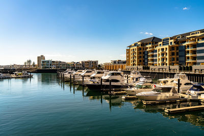 Boats moored in river against buildings in city