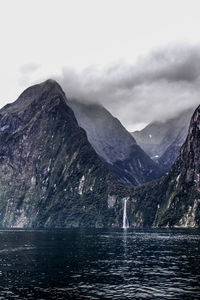 Scenic view of lake by mountains against sky