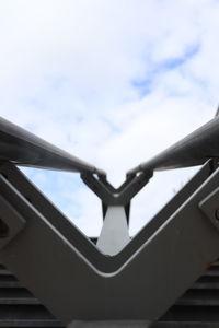 Low angle view of metal railing against sky