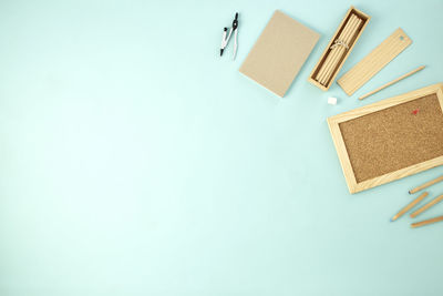High angle view of colored pencils on table against blue background