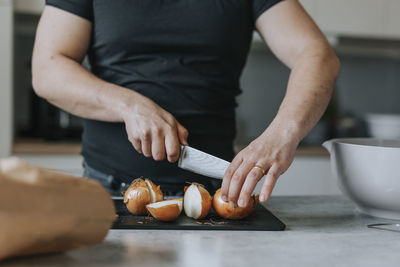 Man's hands cutting onions