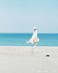 Deck chairs on beach against clear sky