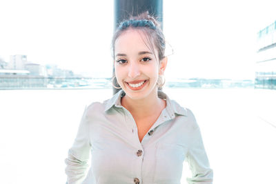 Portrait of young woman standing against sea