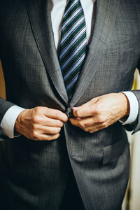 Midsection of businessman wearing suit standing at home