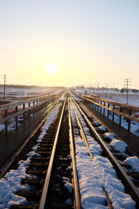 Railroad tracks against sky during winter