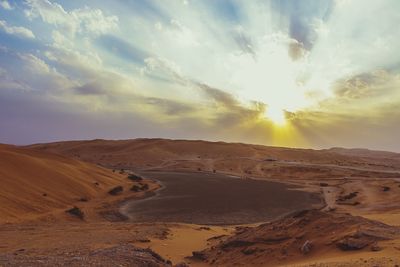 Scenic view of desert against sky during sunset