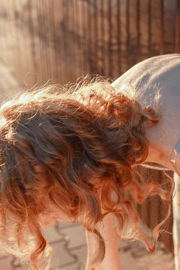 Close-up of woman with brown hair bending outdoors