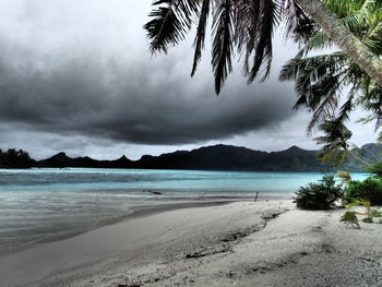 Scenic view of beach against cloudy sky