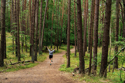 Side view of man walking in forest