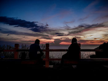 Silhouette people looking at sunset