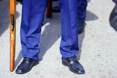 Low section of man standing in blue trouser standing on footpath