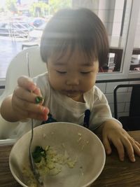 Portrait of cute girl holding ice cream on table